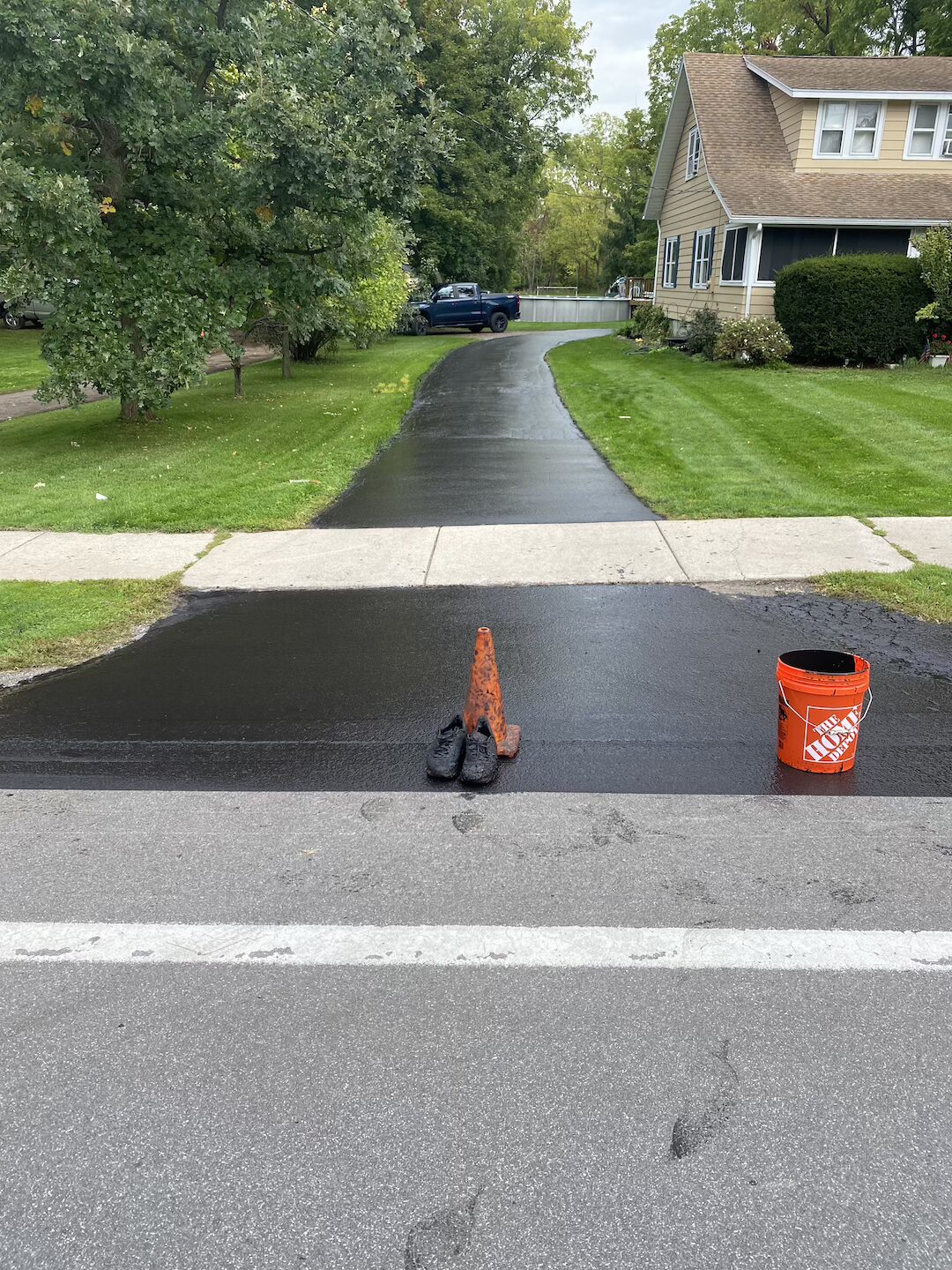 Sealcoating finished on a wide suburban driveway